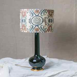 Pantalla de lámpara Kay Guell con motivos geométricos y flores en azules y tierras sobre fondo natural