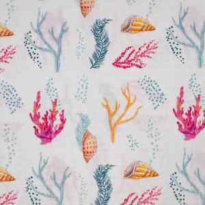 Tela con un alegre y colorido estampado marino de conchas y corales de distintos colores sobre un fondo blanco.