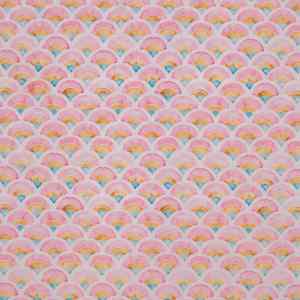 Tela estampada con bonitas formas geométricas en forma de escamas en tonos rosas, ocres y azules.